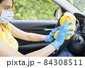Young woman disinfecting her car 84308511