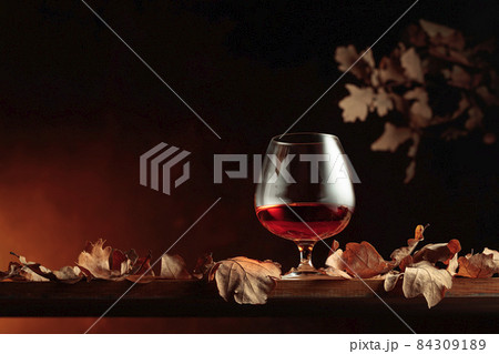 Snifter of brandy and dried-up oak leaves. 84309189