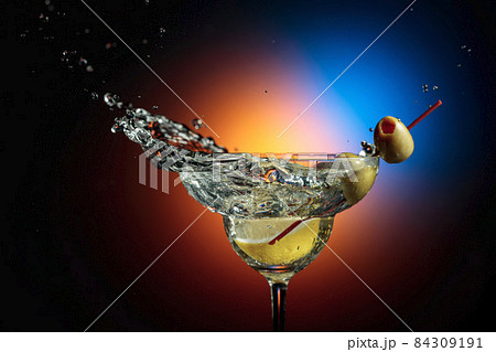 Slice of lemon fall in a glass of martini. 84309191