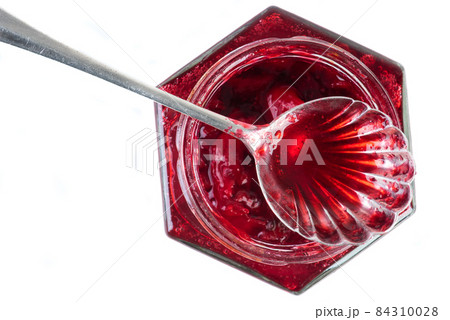 Top view jar of cherry confiture with spoon, close-up, isolated on white background 84310028