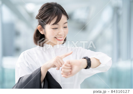 手首に着けたスマートウォッチを見る女性 手首に着けたスマートウォッチを見る女性 84310127