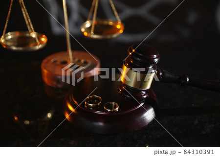 Divorce concept. Judge gavel and wedding rings. Top view Divorce concept. Judge gavel and wedding rings. Top view 84310391