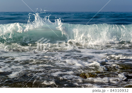 Waves breaking on a stony beach, forming sprays Waves breaking on a stony beach, forming sprays 84310932