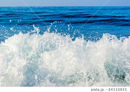 Waves breaking on a stony beach, forming sprays 84310933