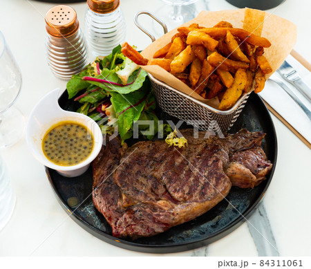Veal entrecote with fried potatoes, fresh greens and caper sauce 84311061