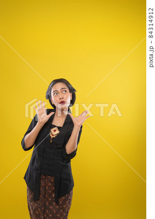 woman with Kebaya dress with surprised gesture with both palms open woman with Kebaya dress with surprised gesture with both palms open 84314912