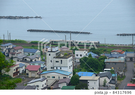 登別市内の富浦集落をかすめて走る室蘭本線の普通列車 84317696
