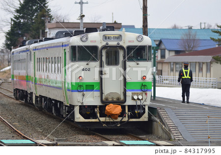 行き違い列車の到着を待つ普通列車と駅員 84317995