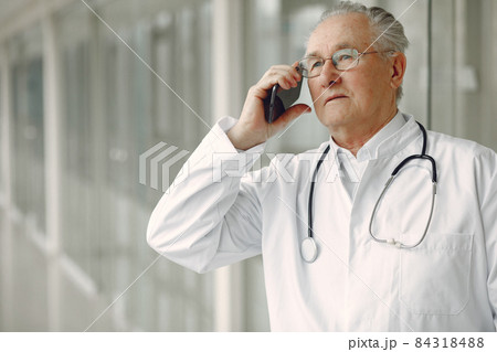Old doctor in a uniform standing at the hall Old doctor in a uniform standing at the hall 84318488