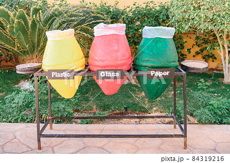 three bins for recycling. sorting debris - plastic, glass and paper. Closeup photo of colorful pots used as garbage containers. It is very important for our planet and ecology to sort your wastes 84319216