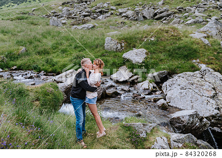 Romantic summer love story on a sunset in mountains. Young girl and boy in love. Romantic summer love story on a sunset in mountains. Young girl and boy in love. 84320268