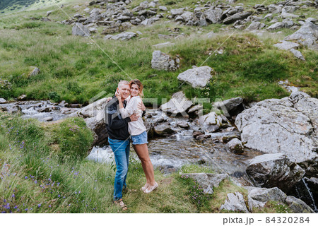 Romantic summer love story on a sunset in mountains. Young girl and boy in love. Romantic summer love story on a sunset in mountains. Young girl and boy in love. 84320284