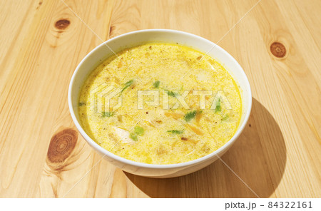 Homemade creamy nettle soup in a deep white plate on a wooden background 84322161