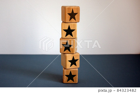 Wood cubes with star sign on beautiful blue table, copy space. White background. Quality and luxury conceptual image. Wood cubes with star sign on beautiful blue table, copy space. White background. Quality and luxury conceptual image. 84323482