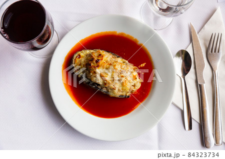 Baked stuffed eggplant served with spicy tomato sauce 84323734