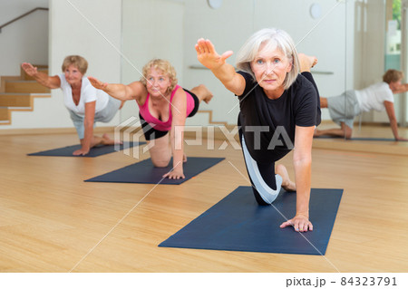 Mature women exercising hands and knees balance 84323791