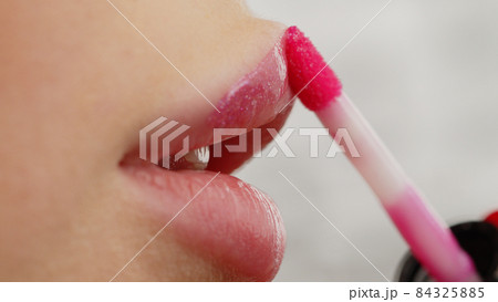 Closeup shot stylist applies lipstick  to the lips of the female model. Woman making make up applying lipstick on a lip. Professional makeup. Tutorial makeup master class. Making mua. Closeup shot stylist applies lipstick  to the lips of the female model. Woman making make up applying lipstick on a lip. Professional makeup. Tutorial makeup master class. Making mua. 84325885