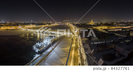 The panoramic view of the winter night city Saint-Petersburg, big ship moored near Blagoveshchensky bridge, Isaac cathedral and Peter and Paul Fortress on background 84327761