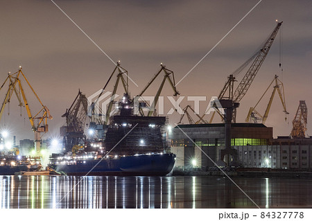 The construction of nuclear icebreakers at night, cranes of of the Baltic shipyard in a frosty winter day, steam over the Neva river, smooth surface of the river, fog The construction of nuclear icebreakers at night, cranes of of the Baltic shipyard in a frosty winter day, steam over the Neva river, smooth surface of the river, fog 84327778
