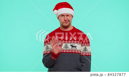Confused man in sweater Santa Christmas hat pointing fingers himself ask say who why me no thanks Confused man in sweater Santa Christmas hat pointing fingers himself ask say who why me no thanks 84327877