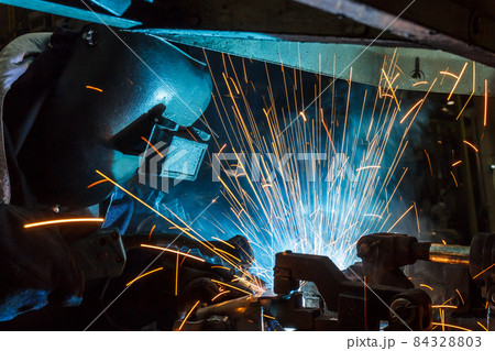 worker with protective mask welding metal 84328803
