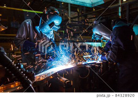 Teamworker with protective mask welding metal Teamworker with protective mask welding metal 84328920