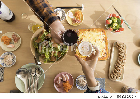 女子会イメージ　食卓に並んだ料理と乾杯をする女性手元 84331057