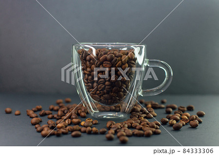 Transparent coffee cup full of coffee beans. 84333306