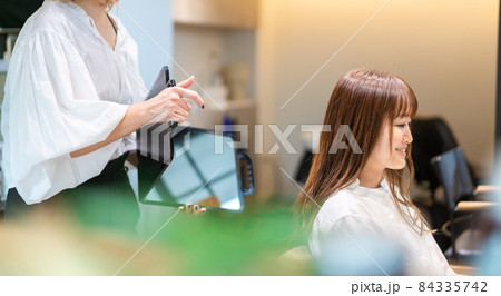 ミラーでヘアスタイルの確認をする美容師 84335742