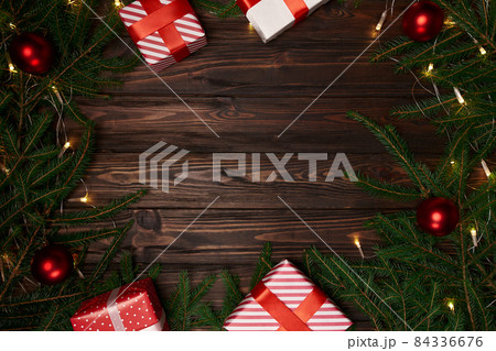 gift boxes and fir branches on a wooden background. 84336676