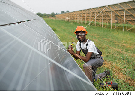 Man in uniform using screwdriver for repairing solar panels Man in uniform using screwdriver for repairing solar panels 84336993