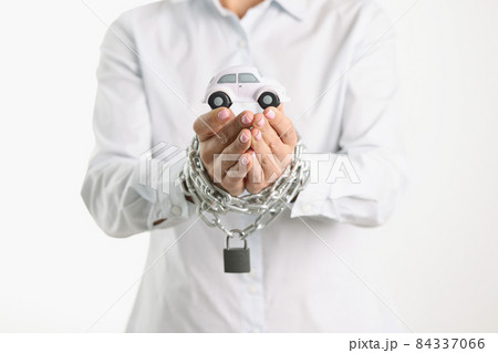 Toy car in female hands wrapped in chain 84337066