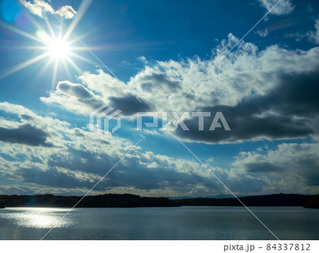 太陽の強い陽射しと穏やかな秋の湖 太陽の強い陽射しと穏やかな秋の湖 84337812