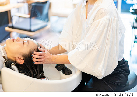 シャンプー台でシャンプーをする美容師 84337871