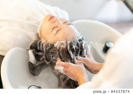 シャンプー台でシャンプーをする美容師 84337874