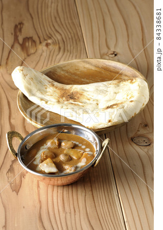 鶏肉や落花生など沢山の具材が入っているマッサマンカレーとナン 84338681