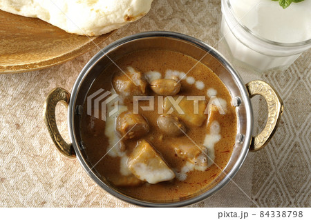 鶏肉や落花生など沢山の具材が入っているマッサマンカレーとナンとラッシ― 鶏肉や落花生など沢山の具材が入っているマッサマンカレーとナンとラッシ― 84338798