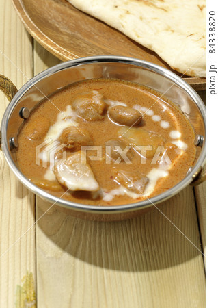 鶏肉や落花生など沢山の具材が入っているマッサマンカレーとナン 84338820