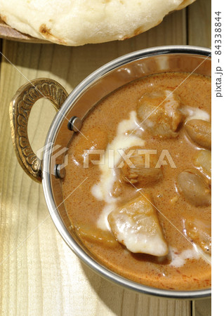 鶏肉や落花生など沢山の具材が入っているマッサマンカレーとナンを俯瞰で撮影 84338844