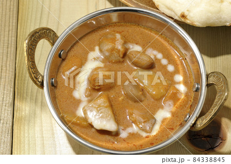 鶏肉や落花生など沢山の具材が入っているマッサマンカレーとナンを俯瞰で撮影 84338845