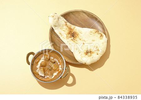 鶏肉や落花生など沢山の具材が入っているマッサマンカレーとナンを俯瞰で撮影 84338935