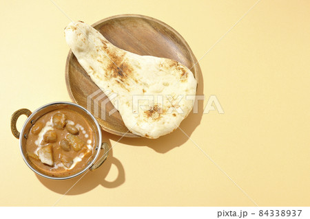 鶏肉や落花生など沢山の具材が入っているマッサマンカレーとナンを俯瞰で撮影 84338937