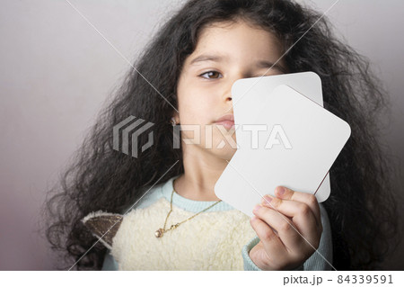 Little girl portrait holding two flash card in hand preschool learning material mock-up series 84339591
