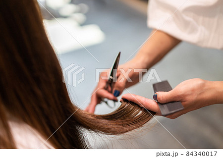 女性のヘアカットをする美容師の写真素材