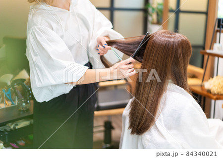 女性のヘアカットをする美容師 女性のヘアカットをする美容師 84340021