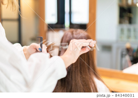 女性のヘアカットをする美容師 女性のヘアカットをする美容師 84340031