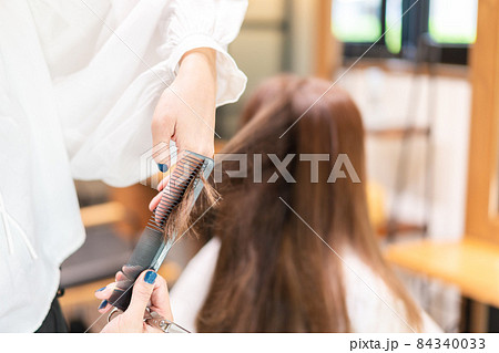 女性のヘアカットをする美容師 84340033
