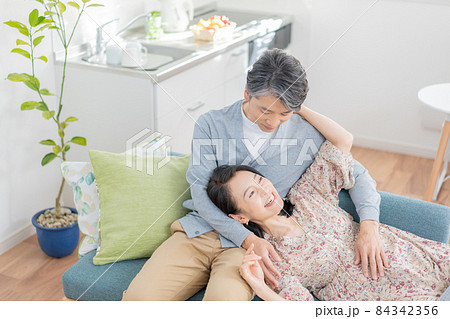 膝枕をするミドルエイジの男性と寝転がる女性 84342356