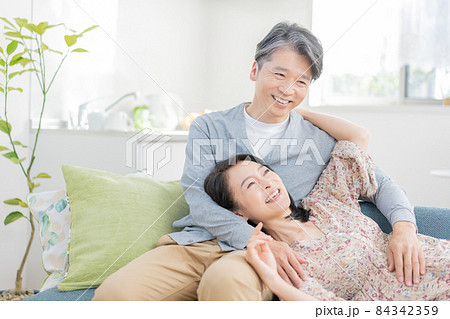 膝枕をするミドルエイジの男性と寝転がる女性 84342359