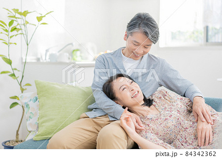 膝枕をするミドルエイジの男性と寝転がる女性 84342362